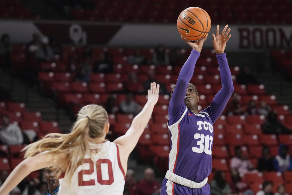 TCU guard Roxane Makolo (30) shoots over Oklahoma guard Aubrey Joens (20) in the first half of an NCAA college basketball game Tuesday, Jan. 31, 2023, in Norman, Okla. (AP Photo/Sue Ogrocki)