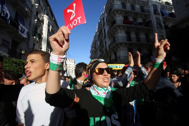 A demonstrator holds a sign reading "No vote" as she takes part in a protest to demand for the presidential election scheduled for next week to be cancelled, in Algiers