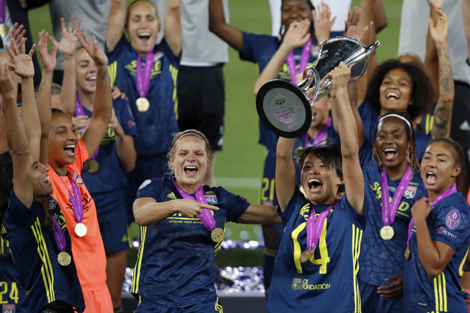 Lyon's Saki Kumagai celebrates with the trophy after winning the Women's Champions League final soccer match between Wolfsburg and Lyon at the Anoeta stadium in San Sebastian, Spain, Sunday, Aug. 30, 2020. Lyon won 3-1. (Clive Brunskill/Pool via AP)