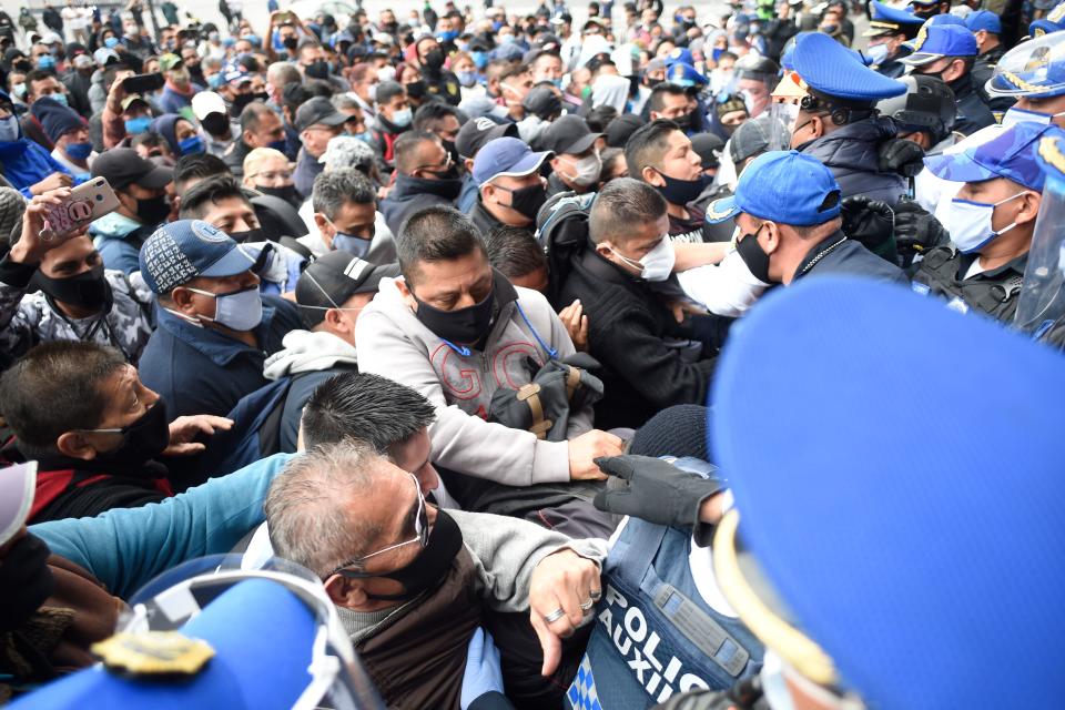 Policías de Ciudad de México contienen a cientos de sus colegas afuera de la sede del gobierno de la capital donde protestaban por salarios no pagados Foto: ALFREDO ESTRELLA/AFP via Getty Images