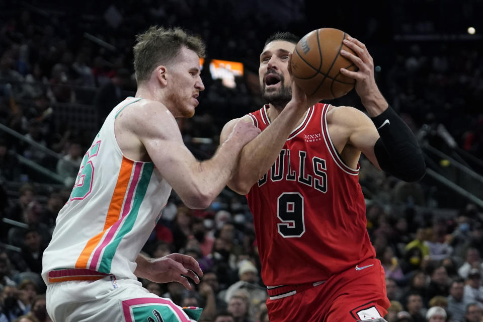 Chicago Bulls center Nikola Vucevic (9) is defended by San Antonio Spurs center Jakob Poeltl (25) as he drives to the basket during the second half of an NBA basketball game, Friday, Jan. 28, 2022, in San Antonio. (AP Photo/Eric Gay)