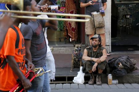 A man and his dog watch a brass band perform on Bourbon Street one day before the ten year anniversary of Hurricane Katrina in New Orleans, Louisiana, August 28, 2015. REUTERS/Jonathan Bachman