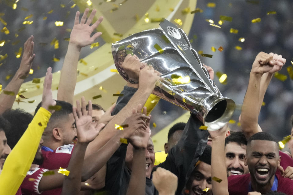 Qatar players celebrate with the trophy after winning the Asian Cup final soccer match between Qatar and Jordan at the Lusail Stadium in Lusail, Qatar, Saturday, Feb. 10, 2024. Qatar won 3-1. (AP Photo/Aijaz Rahi)