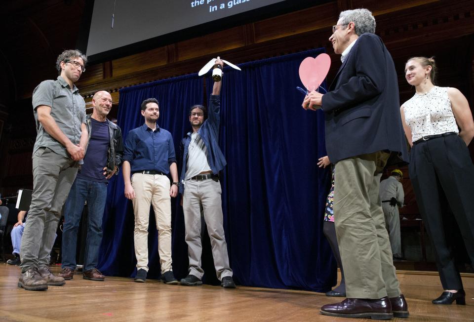 Ig Nobel winners, from left, Paul Becher, Peter Witzgall, Sebastien Lebreton, Felipe Borrero-Echeverry receive the award in biology from Nobel laureate Eric Maskin (economics, 2007), right, during ceremonies at Harvard University in Cambridge, Mass., Thursday, Sept. 13, 2018. The team won for demonstrating that wine experts can reliably identify, by smell, the presence of a single fly in a glass of wine. (AP Photo/Michael Dwyer)