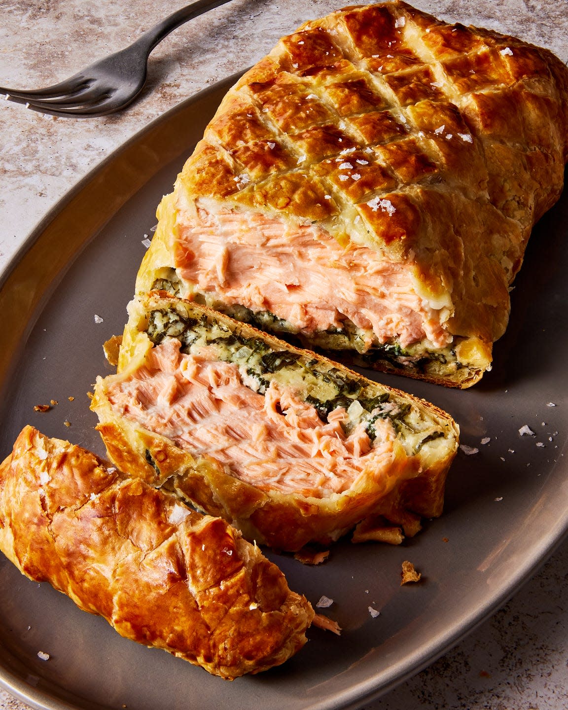 layers of salmon and cream spinach inside of puff pastry