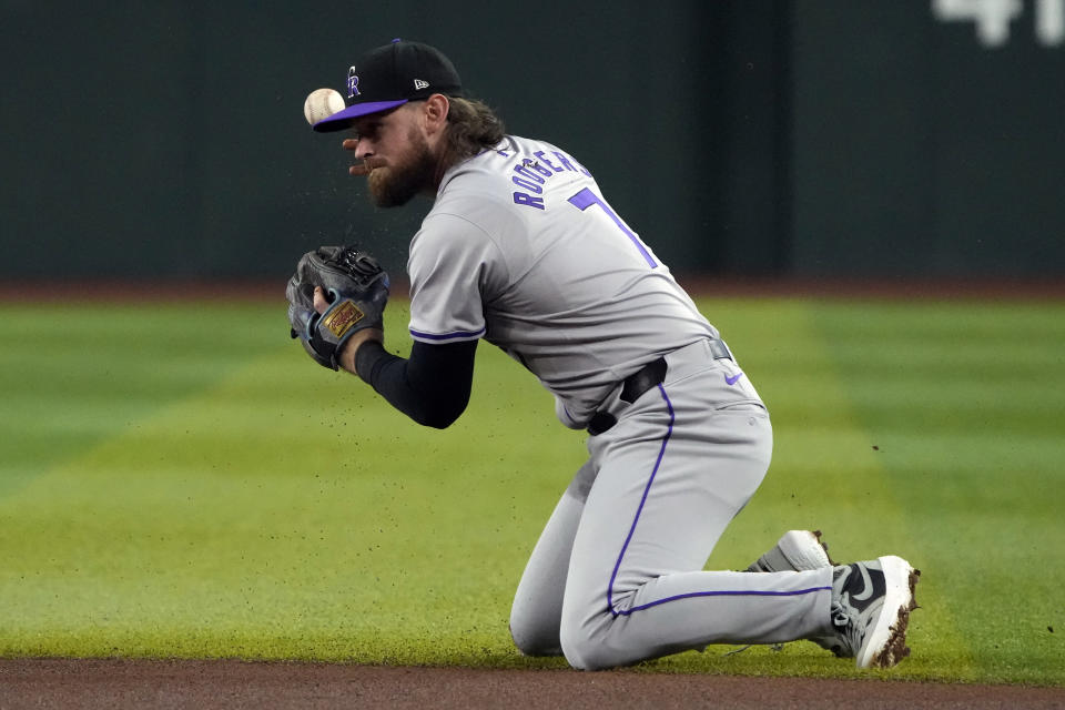 Colorado Rockies second baseman Brendan Rodgers drops the ball on a hit by Arizona Diamondbacks right fielder Corbin Carroll in the first inning during a baseball game, Saturday, March 30, 2024, in Phoenix. (AP Photo/Rick Scuteri)