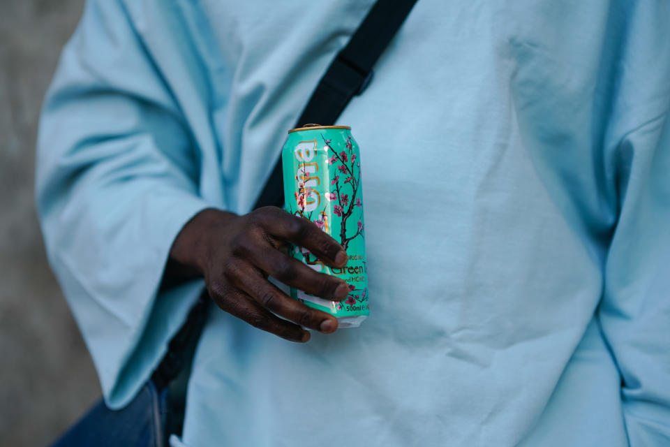 PARIS, FRANCE - FEBRUARY 28: Cali Chiki wears glasses a pale blue oversized pullover from Asos, drinks an Arizona iced tea beverage in a metallic can, on February 28, 2021 in Paris, France. (Photo by Edward Berthelot/Getty Images)