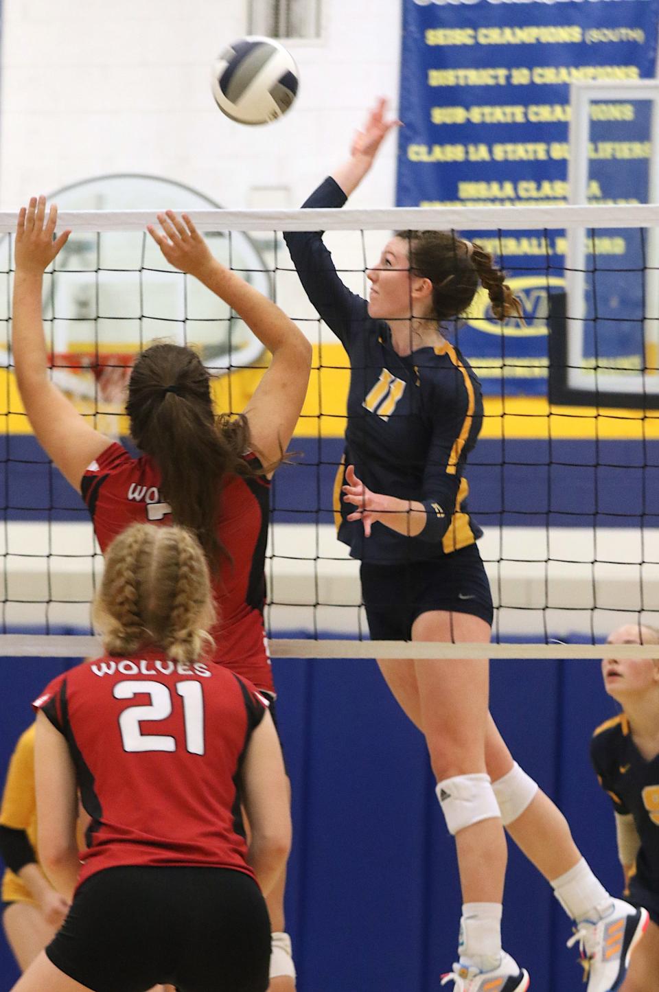 Notre Dame’s Gabby Deery (11) rises for the spike against Winfield-Mount Union’s Keely Malone (7) in a Class 1A regional semifinal Monday in Burlington.