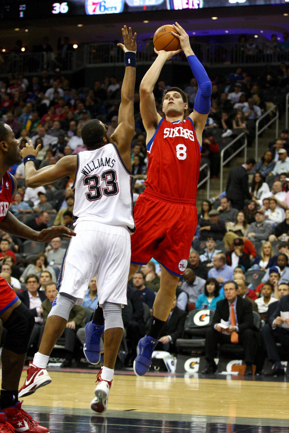 NEWARK, NJ - APRIL 10: Nikola Vucevic #8 of the Philadelphia 76ers attempts a shot in the first half against Shelden Williams #33 of the New Jersey Nets at Prudential Center on April 10, 2012 in Newark, New Jersey. NOTE TO USER: User expressly acknowledges and agrees that, by downloading and or using this photograph, User is consenting to the terms and conditions of the Getty Images License Agreement. (Photo by Chris Chambers/Getty Images)