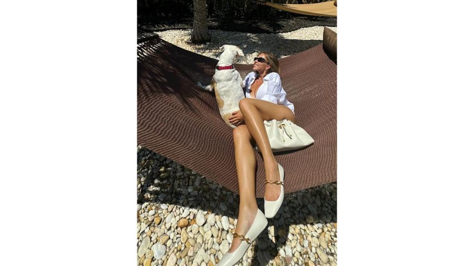 Sydney Sweeney poses on a hammock with her dog