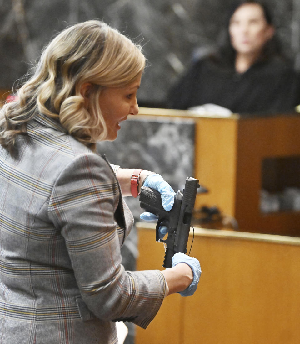 Oakland County Prosecutor Karen McDonald holds a gun, described as the murder weapon, during the James Crumbley trial, in the Oakland County Courtroom on Monday, March 11, 2024, in Pontiac, Mich. He is accused of failing to secure a gun at home and ignoring signs of his son Ethan Crumbley's mental distress. (Daniel Mears/Detroit News via AP, Pool)