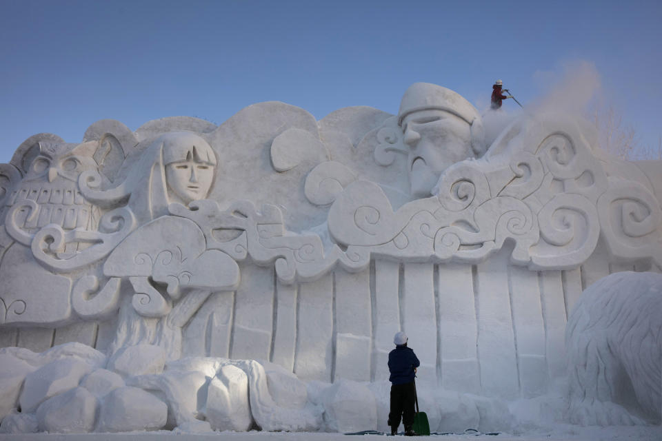 Two workers remove fresh snow piled on a large snow sculpture at the annual Sapporo Snow Festival, Feb. 4, 2020, in Sapporo, Hokkaido, Japan. After two months of almost no snow, Japan's northern city of Sapporo was overwhelmed with the white stuff. The snowfall was good news for tourism, for the “look”of the annual Sapporo Snow Festival, and for organizers who hope to bring the 2030 Winter Olympics to the city. Sapporo hosted the Winter Olympics back in 1972. (AP Photo/Jae C. Hong)