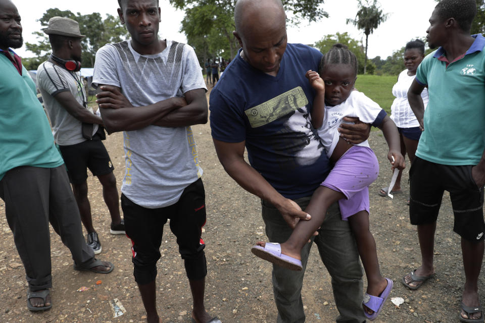 Haitian migrant Jean Bernadeau show insects bites on a girl's legs, at a migrant camp amid the new coronavirus pandemic in Lajas Blancas, Darien province, Panama, Saturday, Aug. 29, 2020. "We know there is a strong illness out there. We can't stay here forever." Said Bernadeau, a who arrived from Chile after living there for five years and saving $4,000 to continue his journey, "Here we live like prisoners in a jail." He said. (AP Photo/Arnulfo Franco)