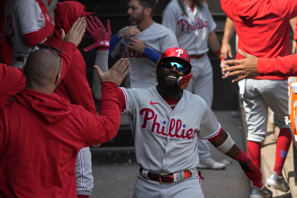 Philadelphia Phillies' Josh Harrison celebrates in the dugout after scoring on a double by Bryson Stott during the fourth inning of a baseball game against the Chicago White Sox Wednesday, April 19, 2023, in Chicago. (AP Photo/Charles Rex Arbogast)