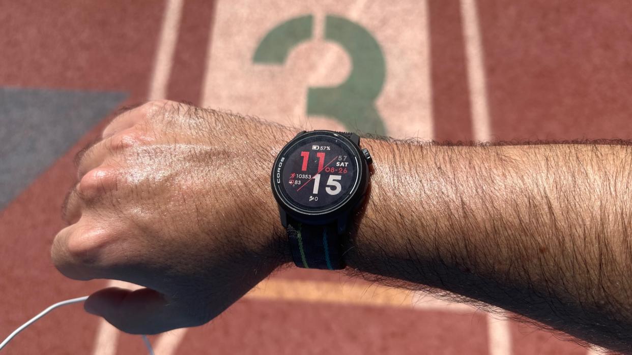  The COROS PACE 3 on the author's wrist, photographed in front of the "3" lane on a track 