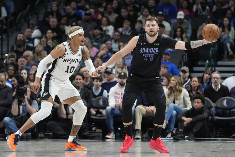 Dallas Mavericks guard Luka Doncic (77) handles the ball against San Antonio Spurs forward Jeremy Sochan (10) during the first half of an NBA basketball game in Dallas, Wednesday, Feb. 14, 2024. (AP Photo/LM Otero)