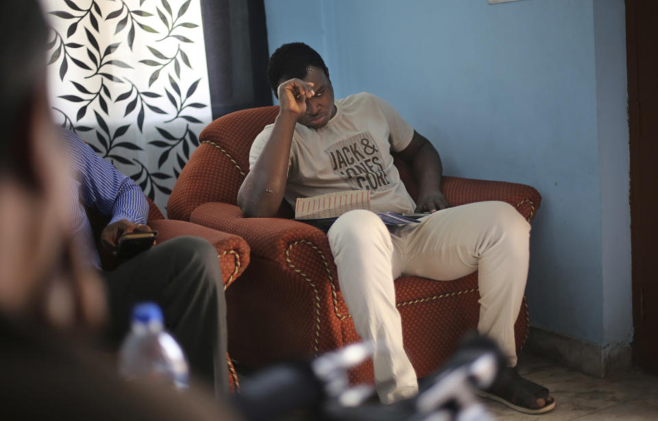 In this Friday, March 31, 2017 photo, Nigerian student Endurance Amalawa, 21, sits on a couch inside his apartment in Greater Noida, India. Endurance's body was dotted with medical staples, on his temple, his cheek and both arms, after dozens of screaming men attacked him with bricks, sticks and belts. The violence started March 24 when a teenage boy disappeared in Greater Noida, outside New Delhi, and angry relatives claimed he'd been killed by his Nigerian neighbors. The African Students' Association in India asked Africans across the capital to remain alert and especially warned those living in Greater Noida from stepping out at all. (AP Photo/Altaf Qadri)