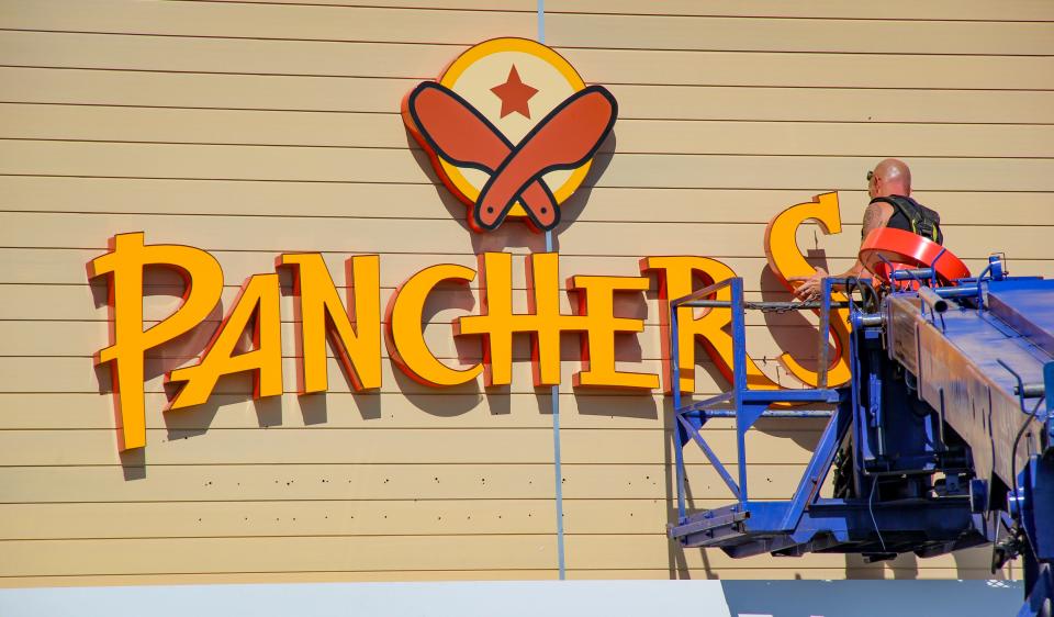 A worker installs the sign for Pancheros Mexican Grill at the fast casual Mexican restaurant chain's location on Route 6 in Somerset.