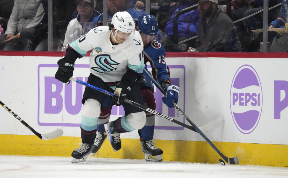 Seattle Kraken center Matty Beniers, left, and Colorado Avalanche right wing Valeri Nichushkin battle for control of the puck in the second period of an NHL hockey game Thursday, Nov. 9, 2023, in Denver. (AP Photo/David Zalubowski)