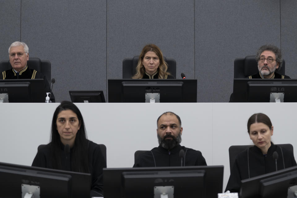 Presiding judge Mappie Veldt-Foglia, top center, prepares to read the verdict in the case of Salih Mustafa, a former Kosovo rebel, at the Kosovo Specialist Chambers court in The Hague, Netherlands, Friday, Dec. 16, 2022. Mustafa is charged with the war crimes of arbitrary detention, cruel treatment, the torture of at least six people and the murder of one person at a detention compound in Zllash, Kosovo, in April 1999. Salih Mustafa pleaded not guilty to all charges. (AP Photo/Peter Dejong, Pool)