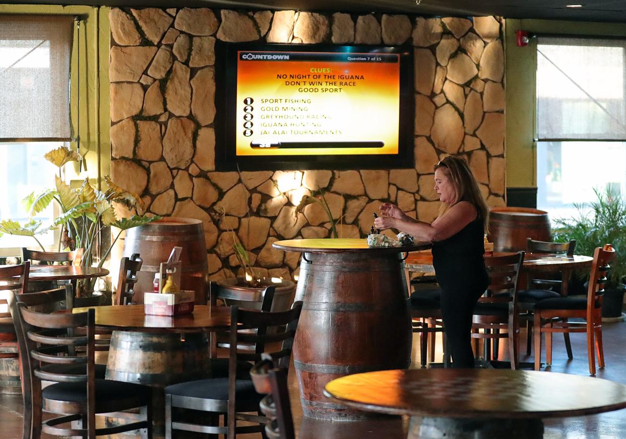 Deanna Jones sets up tabletop games before customers start arriving for trivia night at Punts & Pints, Tuesday, Dec. 13, 2022, in Cuyahoga Falls, Ohio.