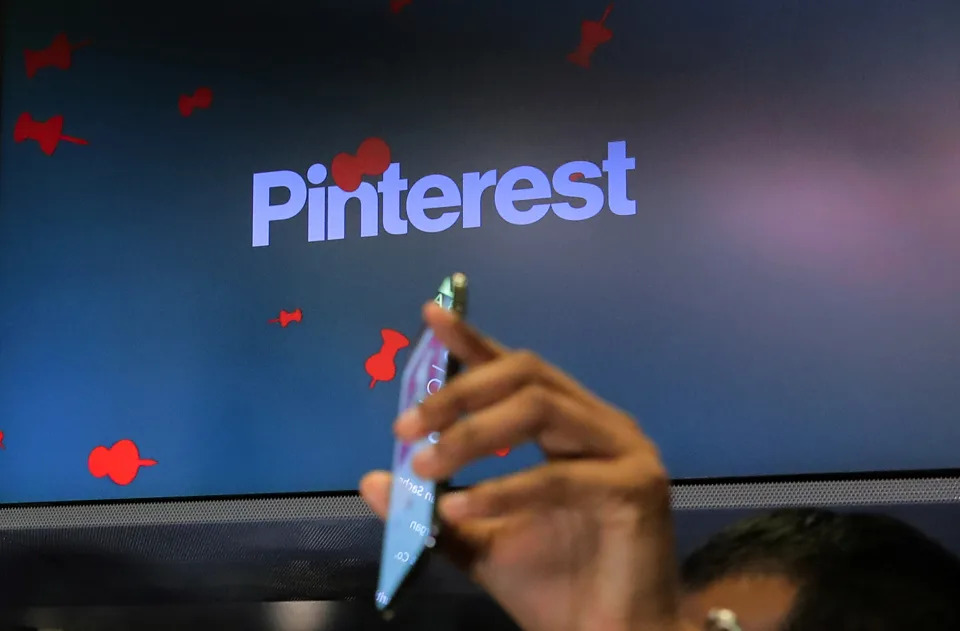A guest hold up a phone during the Pinterest Inc. IPO on the floor of the New York Stock Exchange (NYSE) in New York, U.S., April 18, 2019. REUTERS/Brendan McDermid