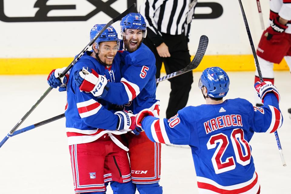 New York Rangers' K'Andre Miller (79) celebrates with Ben Harpur (5) and Chris Kreider (20) after scoring a goal during the third period of an NHL hockey game against the Carolina Hurricanes Tuesday, Jan. 3, 2023, in New York. The Rangers won 5-3. (AP Photo/Frank Franklin II)