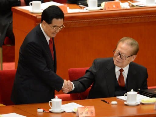 Chinese President Hu Jintao (left) shakes hands with his predecessor Jiang Zemin after delivering his address at the opening of the 18th Communist Party Congress at the Great Hall of the People in Beijing on November 8