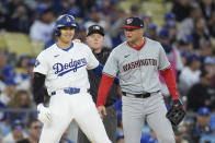 Los Angeles Dodgers' Shohei Ohtani, left, jokes with Washington Nationals third baseman Nick Senzel during the first inning of a baseball game Monday, April 15, 2024, in Los Angeles. (AP Photo/Marcio Jose Sanchez)