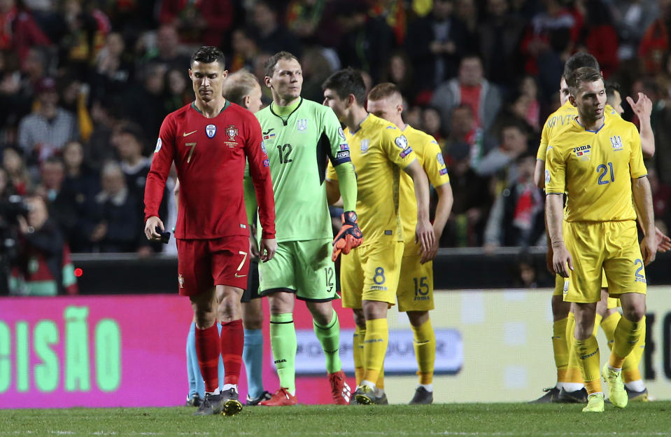 Portugal's Cristiano Ronaldo, left, walks with Ukraine goalkeeper Andriy Pyatov, third from left, at the end of the Euro 2020 group B qualifying soccer match between Portugal and Ukraine at the Luz stadium in Lisbon, Friday, March 22, 2019. (AP Photo/Armando Franca)