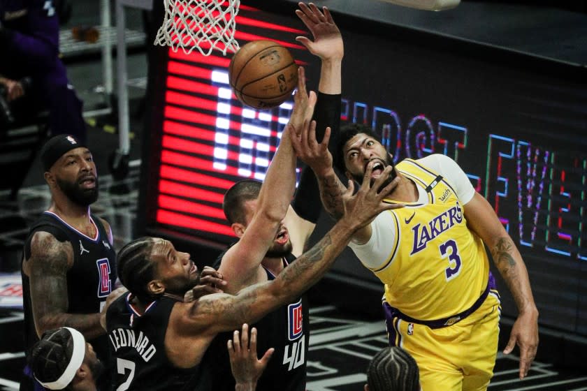 LOS ANGELES, CA - MAY 6, 2021: Los Angeles Lakers forward Anthony Davis (3) tries a reverse lay-up, but runs in to the defense of LA Clippers center Ivica Zubac (40) and LA Clippers forward Kawhi Leonard (2) in the first half at Staples Center on May 6, 2021 in Los Angeles, California.(Gina Ferazzi / Los Angeles Times)