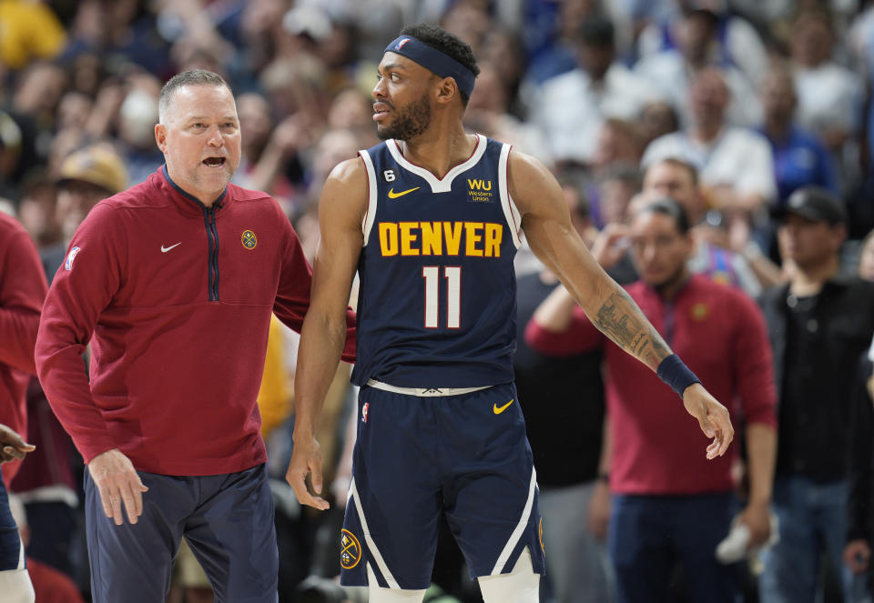 Denver Nuggets head coach Michael Malone, left, guides forward Bruce Brown away from Phoenix Suns guard Devin Booker after they engaged in a dust-up late in the second half of Game 2 of an NBA second-round playoff series Monday, May 1, 2023, in Denver. (AP Photo/David Zalubowski)