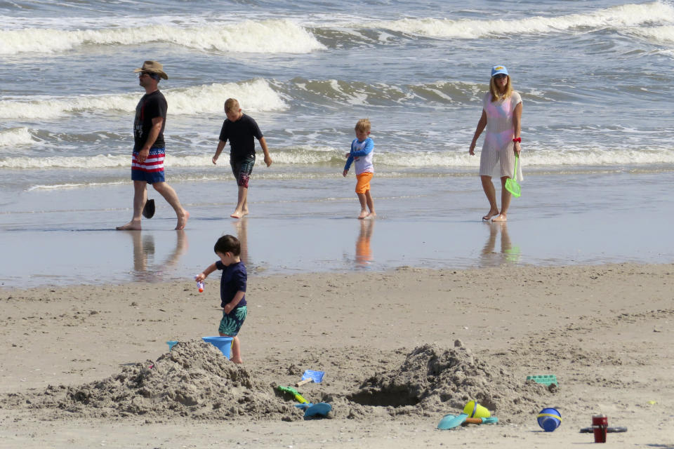 Beachgoers walk along the shoreline in Brigantine N.J. on June 28, 2022. On April 24, 2023, a panel of Democratic federal officials and New Jersey environmental groups said climate change is the biggest threat to marine life in the ocean, not preparatory work for offshore wind farms, which some people believe are harming or killing whales on the East Coast despite government agencies' statements that the two are not related. (AP Photo/Wayne Parry)