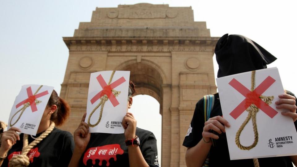 Activistas de Amnistía Internacional con capuchas negras y una soga alrededor del cuello mientras protestan contra la pena de muerte en Nueva Delhi en octubre de 2008.