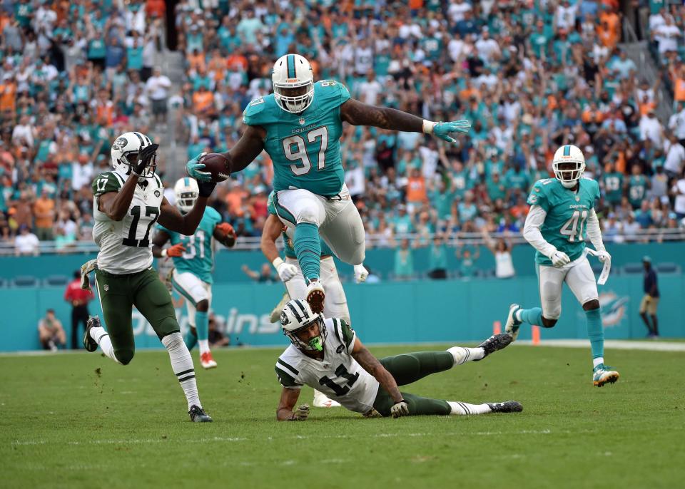 <p>Miami Dolphins defensive tackle Jordan Phillips (97) leaps over New York Jets wide receiver Robby Anderson (11) after making an interception during the second half at Hard Rock Stadium. The Dolphins won 27-23. Mandatory Credit: Steve Mitchell-USA TODAY Sports </p>