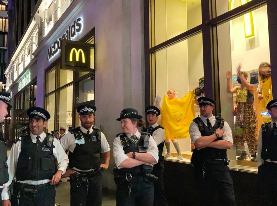 Police guard the McDonald's where Animal Rebellion protesters glued themselves to windows. (Twitter/Animal Rebellion)