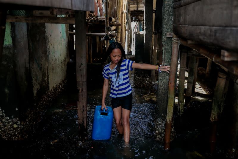 The Wider Image: Rising seas threaten early end for sinking village in Philippines
