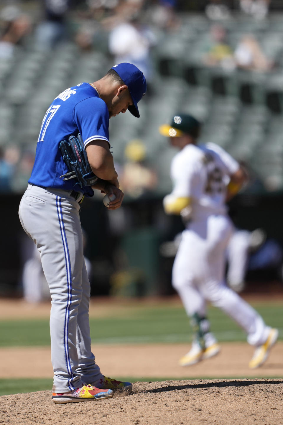 Toronto Blue Jays pitcher Jose Berrios, foreground, reacts after Oakland Athletics' Ryan Noda, rear, hit a home run during the sixth inning of a baseball game in Oakland, Calif., Monday, Sept. 4, 2023. (AP Photo/Jeff Chiu)