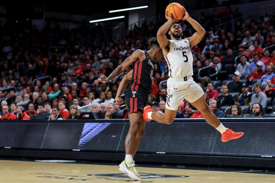 Feb 22, 2023; Cincinnati, Ohio, USA;  Cincinnati Bearcats guard David DeJulius (5) reacts as he is fouled by Temple Owls guard Jahlil White (2) in the first half at Fifth Third Arena.