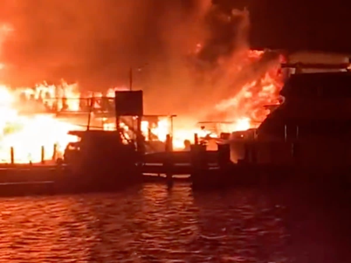 A fire burns at Seaport Marine in Mystic, Connecticut, ultimately destroying two buildings and a boat (screengrab/Twitter/@melanierose)