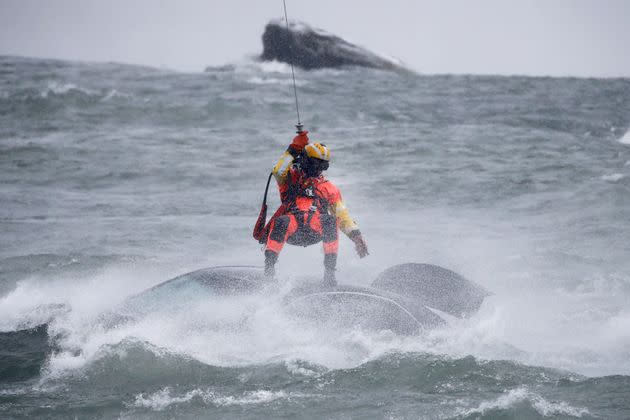 A U.S. Coast Guard diver is lowered from a helicopter to pull a body from a submerged vehicle stuck in rushing rapids just yards from the brink of Niagara Falls on Wednesday. (Photo: Jeffrey T. Barnes via AP)