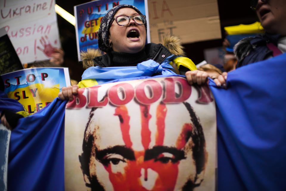 Pro-Ukraine people hold banners as they shout slogans during a protest outside the Russian consulate in Istanbul, Turkey, Friday, Feb. 25, 2022, after Russian troops have launched an invasion on Ukraine. (AP Photo/Francisco Seco)