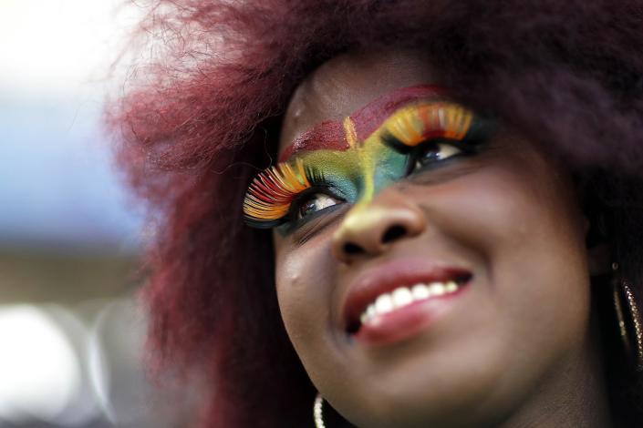 A smiling woman wears false eyelashes and the colours of the Senegalese flag in face paint at an Under-20 World Cup football match against Colombia in La Plata, Argentina - Saturday 27 May 2023