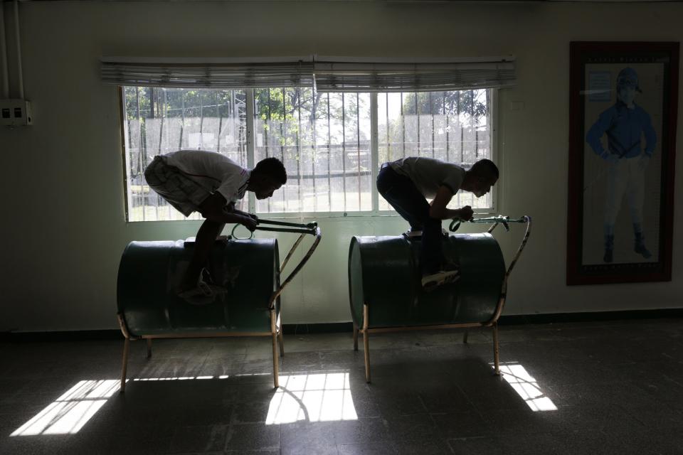 Dos aprendices a ser jinetes de caballos practican su posición encima de dos barriles de petróleo, en la Escuela de Jinetes en Ciudad de Panamá.