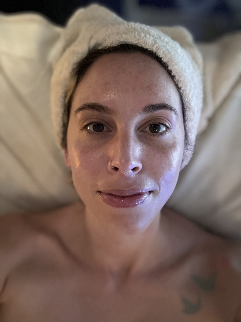 Woman with headband lying down, receiving a spa facial treatment, relaxing