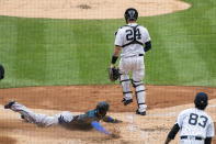 Miami Marlins' Monte Harrison (4) slides into safely home behind New York Yankees catcher Gary Sanchez (24) on a double hit by Marlins' Miguel Rojas during the third inning of a baseball game at Yankee Stadium, Saturday, Sept. 26, 2020, in New York. (AP Photo/Corey Sipkin)