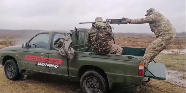 Ukrainian soldiers shooting from the back of a van retrofitted by Car4Ukraine