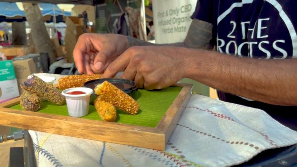 Lopez arranges two of his signature croqueta styles for display at the farmers market- Taro Cookies & Creme and Lemon-Garlic Cilantro.