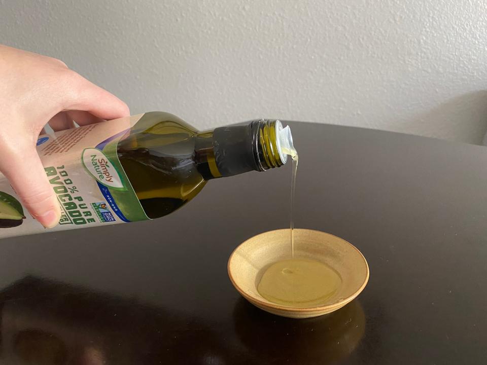 Writer pouring Simply Nature avocado oil into a small bowl