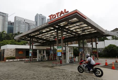 A motorist arrives to purchase fuel at a Total petrol station in south Jakarta February 12, 2015. REUTERS/Darren Whiteside